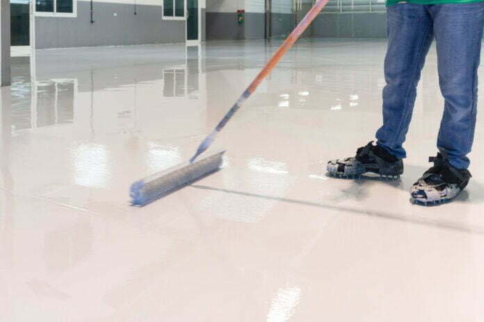 Construction series: Worker working on epoxy floor Is Epoxy Floor Hard to Maintain in Cold Areas?